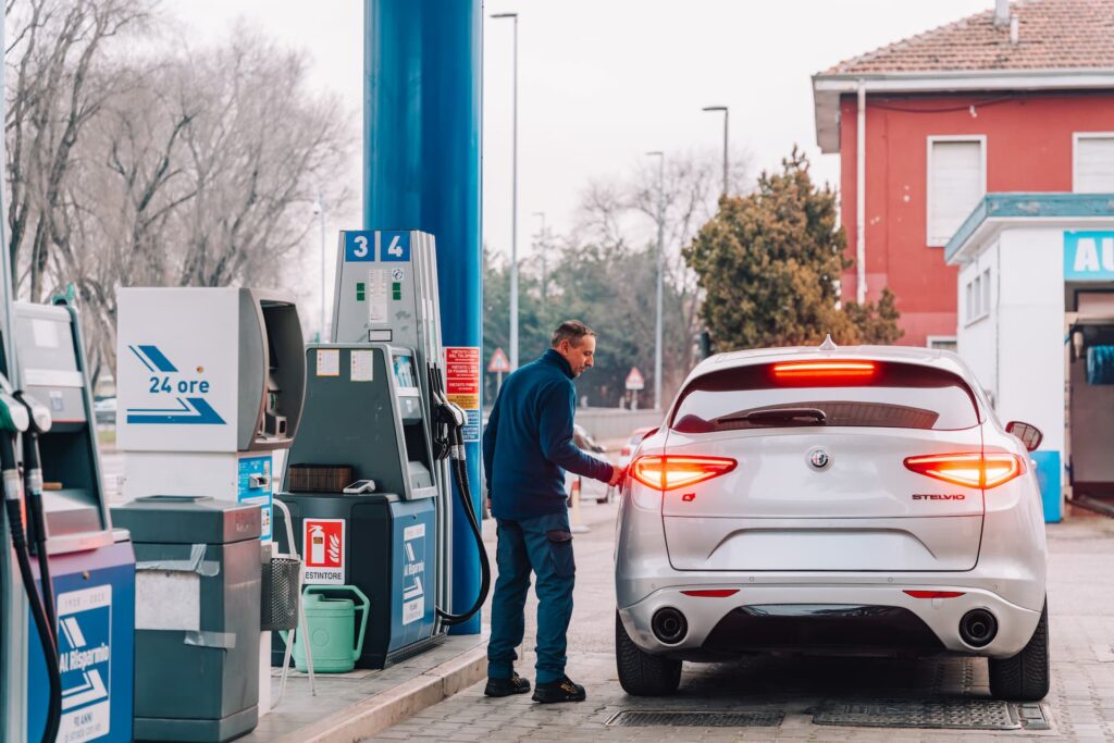 Addetto di una stazione di servizio che fa rifornimento a un cliente
